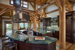 Woodhouse Post and Beam kitchen with dark wood cabinets and doug fir timbers.